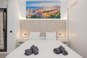 a bedroom with a white bed with two pillows at Aptos Turísticos Playa Marinsa in Torre del Mar +178 photos