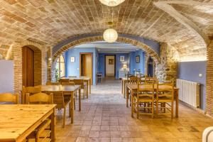 a dining room with wooden tables and chairs at Mas la Ginesta in Borrassá