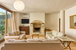 a living room with two couches and a fireplace at Mas la Ginesta in Borrassá
