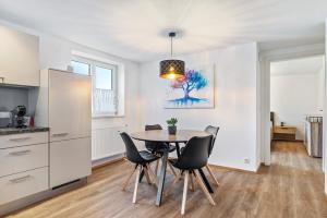 a kitchen and dining room with a table and chairs at Apartments Winder 2 in Lustenau +6 photos