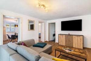 a living room with a couch and a flat screen tv at Apartments Winder 2 in Lustenau