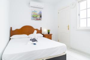 a bedroom with a bed with a white bedspread at Kays studio in Puerto del Carmen
