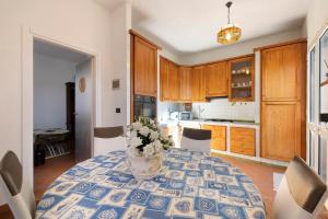 a kitchen with a table with a vase of flowers on it at Home Charlene parking e patio in Albenga