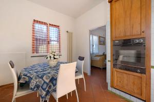 a kitchen and dining room with a table and chairs at Home Charlene parking e patio in Albenga