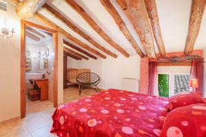 a bedroom with a red bed and a bathroom at La Casica del Sol in Requena