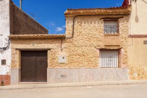 a stone building with a door and a balcony at La Casica del Sol in Requena