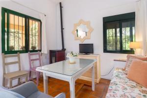 ein Wohnzimmer mit einem Tisch und einem Sofa in der Unterkunft Finca El Chopo - piscina compartida in Alájar