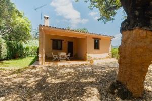 Außenansicht eines Hauses mit Tisch und Stühlen in der Unterkunft Finca El Chopo - piscina compartida in Alájar