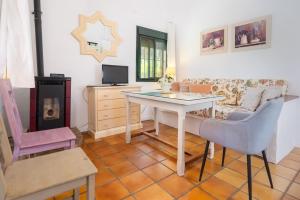 ein Wohnzimmer mit einem Tisch und einem Sofa in der Unterkunft Finca El Chopo - piscina compartida in Alájar