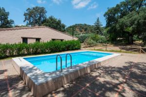 ein Swimmingpool vor einem Haus in der Unterkunft Finca El Chopo - piscina compartida in Alájar