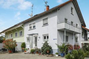 a white house with a balcony on the side of it at Ferienwohnung Eberle in Eriskirch