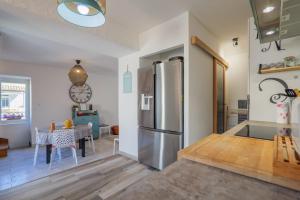 a kitchen with a stainless steel refrigerator and a table at Gite Leoannatim in Ruoms