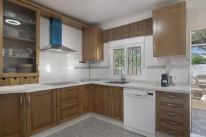 a kitchen with wooden cabinets and white appliances at Chalet Los Paul in Chiclana de la Frontera