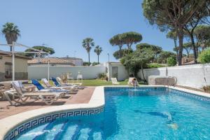 a swimming pool with chairs and a dog in the water at Chalet Los Paul in Chiclana de la Frontera