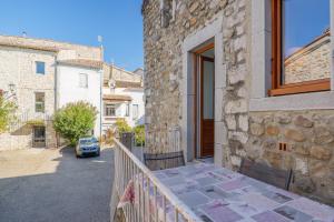 a stone house with a table on a balcony at Gite Leoannatim in Ruoms