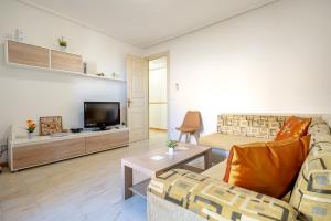 a living room with a couch and a tv at Apartamentos El Compromiso in Caspe