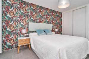 a bedroom with a large bed with a floral wallpaper at El ático del Oasis in Salobreña +23 photos