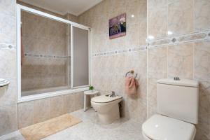 a bathroom with a toilet and a sink and a shower at Apartamentos El Compromiso in Caspe +16 photos