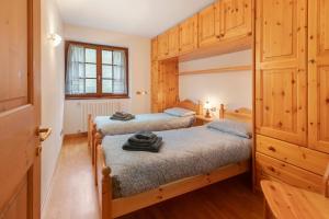 two twin beds in a room with wooden cabinets at Fior di montagna in Bormio