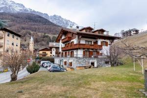 a building on a hill with cars parked in front of it at Fior di montagna in Bormio