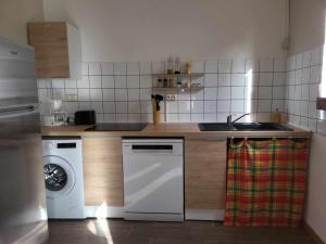 a kitchen with a sink and a washing machine at Gîte KAZ' A TYKA jacuzzi privatif in Saint-François