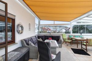 a patio with a couch and a table and chairs at Haus Domblick in Gückingen