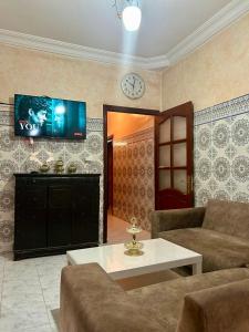 a living room with a couch and a tv on the wall at Airport agadir villa in Agadir