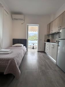 a bedroom with a bed and a kitchen with a view at Vila Melina in Himare