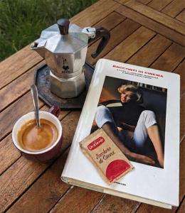 a book on a table with a cup of coffee and a pastry at B&B Casal Cominium in San Donato Val di Comino
