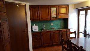 uma cozinha com armários de madeira e uma mesa com um lavatório em Maison Rosalp em Breuil-Cervinia