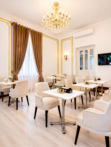 a dining room with tables and chairs and a chandelier at Downtown Antique Hotel in Cairo