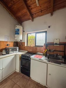 a kitchen with a stove and a sink and a window at Madre America Hotel & Hostel in San Ignacio