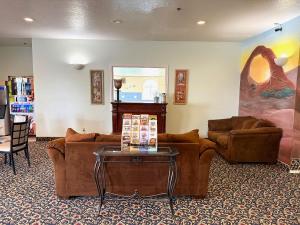 a living room with two couches and a table at Horizon Hotel in Vernal