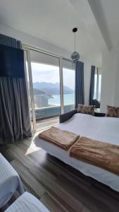 a bedroom with a large bed and a large window at Skyline sea view apartment in Bečići