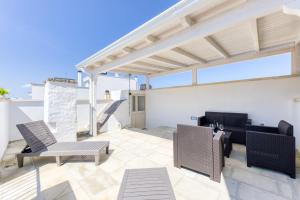 a patio with chairs and tables on a roof at Casa Don Michele in Specchia