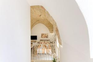 a hallway with an archway in a building with a table at Casa Don Michele in Specchia