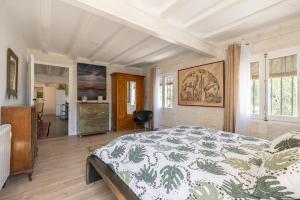 a bedroom with a bed with a green and white comforter at La Fabriqueta Apartament in Ríudecañas