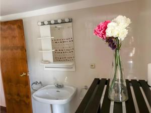 a vase of flowers on a table next to a sink at Nogal in Hospital