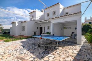 a ping pong table in front of a white house at Villa Martins in Albufeira