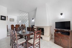a dining room with a table and a television at Villa Martins in Albufeira