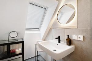 a bathroom with a white sink and a mirror at Historisches Forstamt in Gernsbach +16 photos