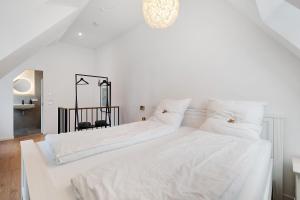 a white bedroom with two beds with white sheets at Historisches Forstamt in Gernsbach