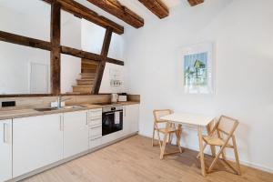 a kitchen with white cabinets and a table and chairs at Historisches Forstamt in Gernsbach