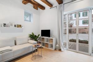 a white living room with a white couch and a tv at Historisches Forstamt in Gernsbach