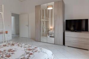a bedroom with a bed and a tv and a mirror at Giada Apartment in Calenzano