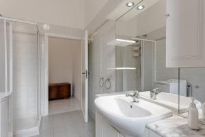 a white bathroom with a sink and a shower at Giada Apartment in Calenzano +16 photos