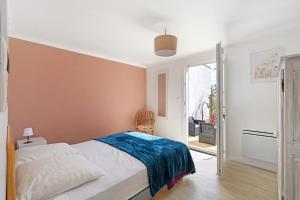 a bedroom with a bed and a sliding glass door at Les Passiflores - Chambre d'Hôtes in Pornic