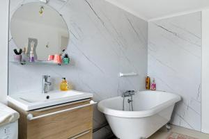 a white bathroom with a sink and a mirror at Les Passiflores - Chambre d'Hôtes in Pornic