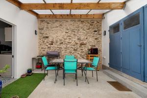 a table and chairs in a room with a brick wall at Les Passiflores - Chambre d'Hôtes in Pornic +10 photos