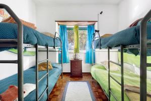 a room with three bunk beds and a window at Casa Campo e Mar in Encarnação